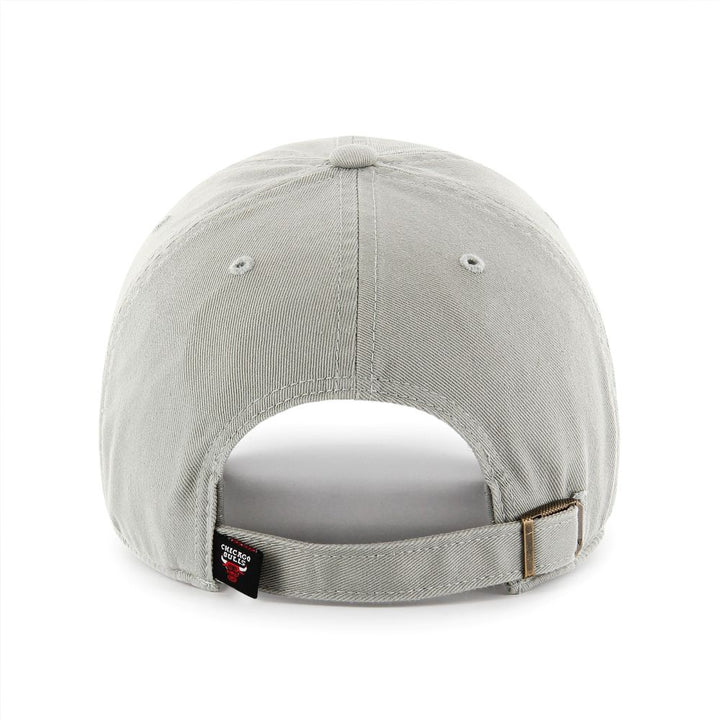 The Chicago Bulls '47 Clean Up Cap is a light gray cotton twill hat shown from the back, featuring an adjustable strapback with a brass buckle and a small black tag on the left side of the opening.