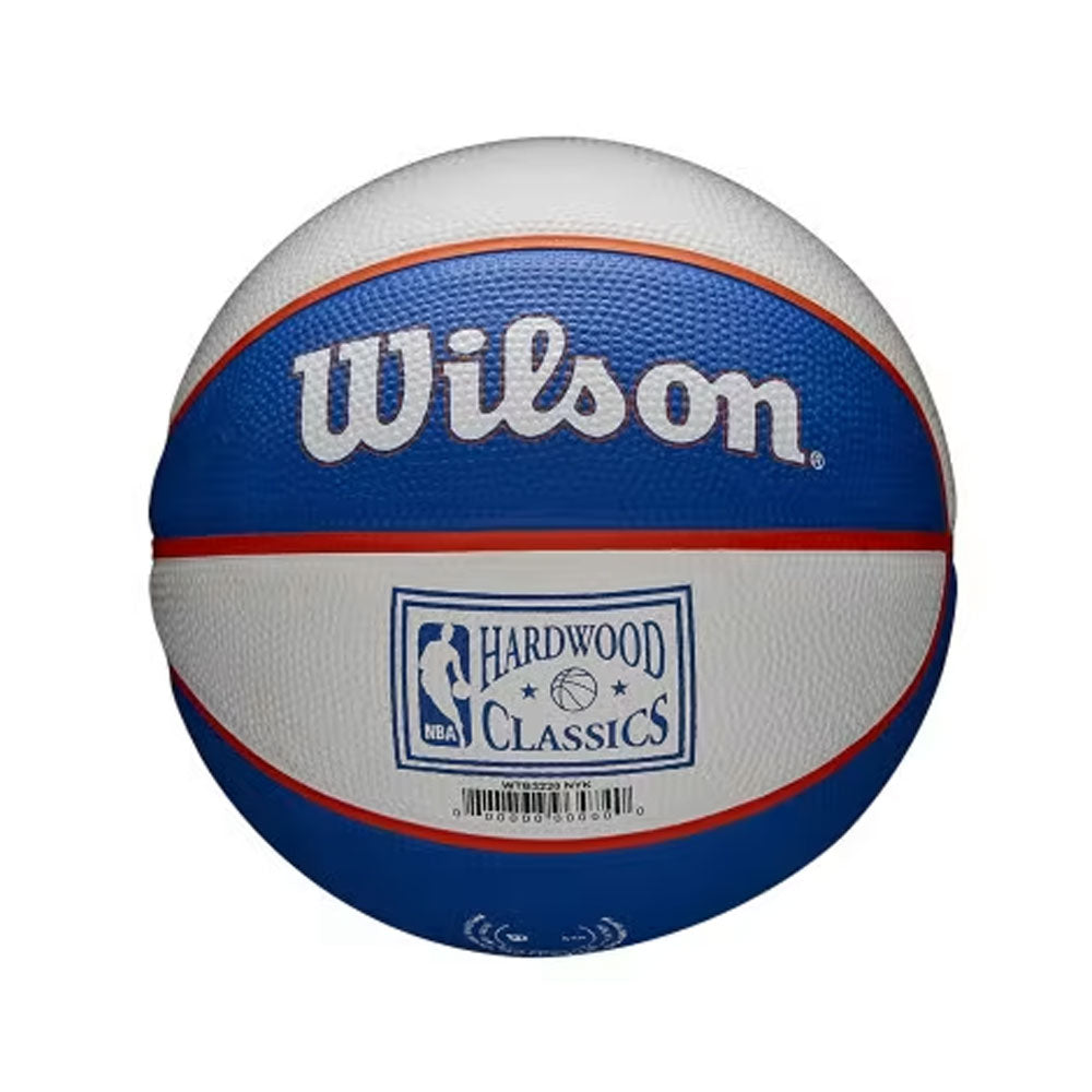 The Wilson NBA New York Knicks Mini Basketball features blue, white, and red panels, NBA PRO SEAMS, a Hardwood Classics NBA logo, and a barcode on the front—perfect for young fans or as a collectible item.