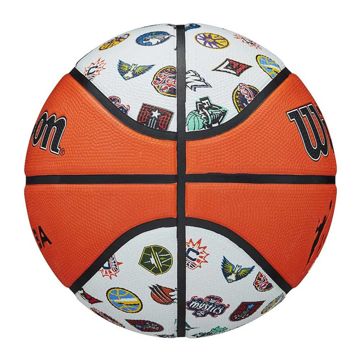 The Wilson WNBA All Team Basketball features white panels with colorful WNBA team logos, classic orange panels, black lines, and the Wilson logo on two sides—perfect for kids.