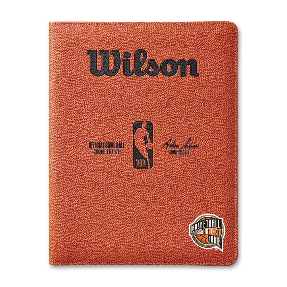 The Basketball Hall of Fame x Wilson NBA Padfolio is a textured orange padfolio with a basketball design, featuring the Wilson logo, NBA logo, commissioner's signature, and the Hall of Fame emblem on the bottom right corner.