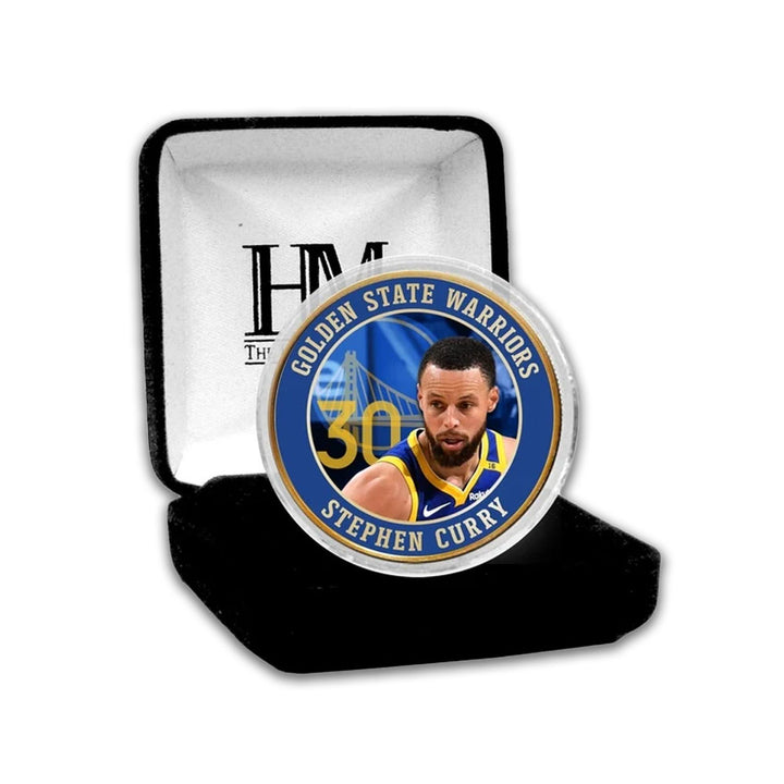 The NBA Golden State Warriors Steph Curry Bronze Commemorative Coin features Curry in his team jersey, number 30, and the team name on a blue background, presented in a black velvet case—an ideal collector's item.