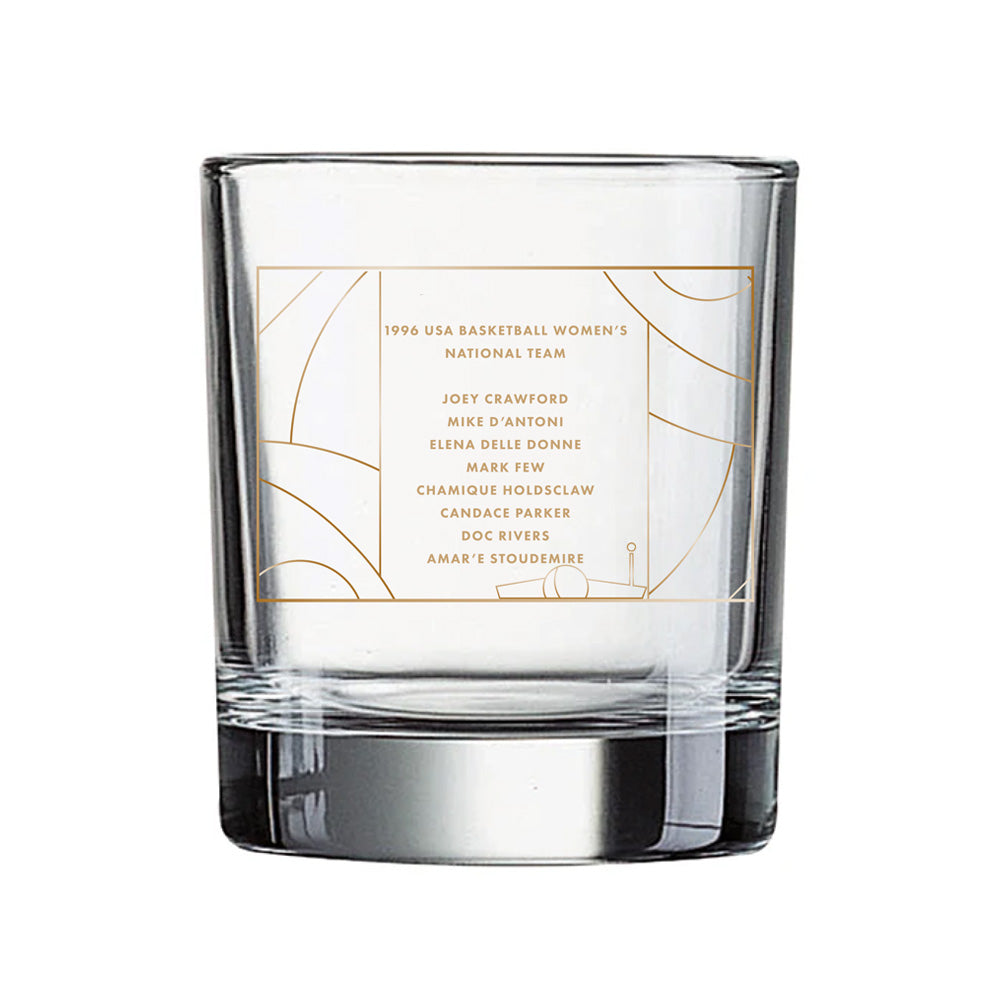 Celebrate the 2026 Enshrinement with the Basketball Hall of Fame® 2026 Enshrinement Rocks Glass, featuring a gold-bordered label listing names under the heading “1996 USA Basketball Women’s National Team” on a clear glass, set against a white and gold abstract background—a must-have collectible and keepsake for basketball fans.